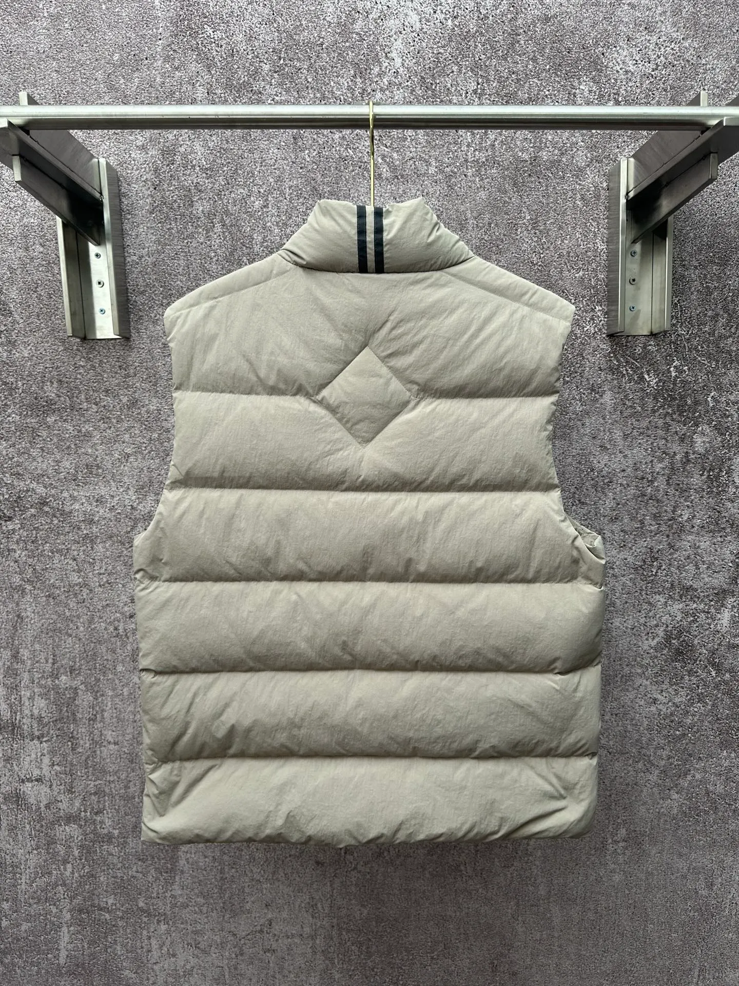 P720 Canada Goose Badge Down Vest Fabric selection: The use of high-quality protective nylon fabric not only enhances the wear resistance of the surface, but also takes into account wind resistance, ensuring excellent performance in various harsh weather conditions.  90 national standard high-quality white duck down: selected high-loft down, weighing 160g, light and warm, with excellent temperature locking performance and good resilience.  Three-dimensional quilting process: Precision thread reinforcement to prevent velvet drilling and ensure that the fluffy and resilient elasticity lasts as new.  Details: The ribbon is woven with polyester as the base, and the brand letters are decorated on the ribbon through high-precision computer embroidery. The edges of the pattern are clear, the stitches are fine and even, and multiple layers of embroidery thread are stacked to enhance the three-dimensional effect. Accessories: One-to-one customized logo, one-to-one customized zipper puller, one-to-one customized three-label SIZE: S M L XL